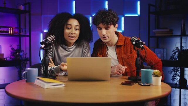Male and female podcasters commenting video game on laptop during live stream