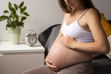 pregnant woman sits in the bed