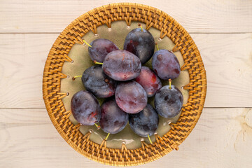 Sweet plums on a wooden table, close-up, top view.