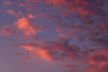 Vibrant sunset sky with soft pink and purple clouds creating a dreamy, colorful and peaceful background.
