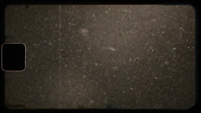 A grainy and dirty film effect overlay with a black rounded square in the left corner frame edge