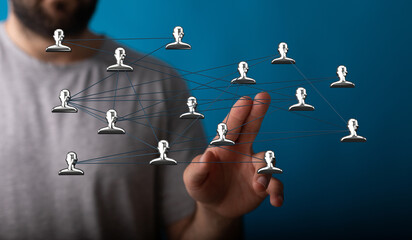 Conceptual image of a hand touching a network of connected human figures, representing concepts...