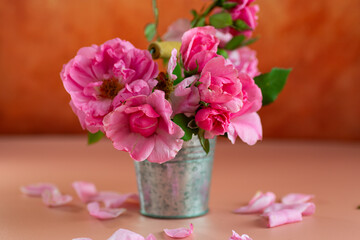 Delicate pink roses in a bucket
