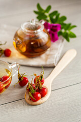 Medicinal rosehip tea in a cup on a wooden table