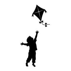 Silhouette of young child reaching for kite in flight