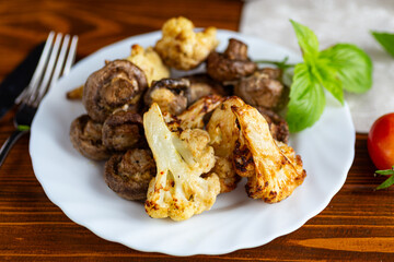 Roasted cauliflower and mushrooms served on white ceramic plate