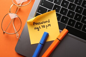 Naklejka na ściany i meble Paper note with password, markers, glasses and laptop on orange background, flat lay Naklejka na ściany i meble Paper note with password, markers, glasses and laptop on orange background, flat lay