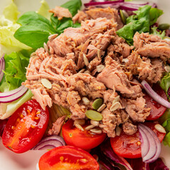 Tuna salad canned fish, tomato, green leaf salad vegetable dish natural tasty snack fresh gourmet food background on the table rustic top view copy space keto and paleo diet food pescetarian diet