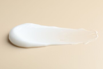 Sample of moisturizing cream on beige background, closeup