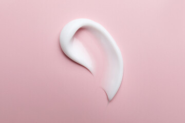 Sample of moisturizing cream on pink background, top view