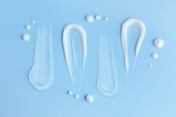 Samples of different cosmetic products on light blue background, flat lay