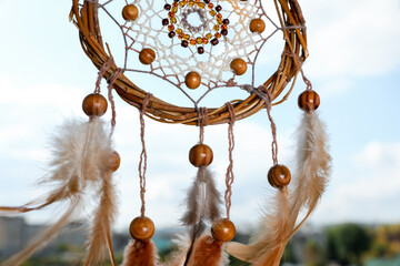 Shamanism. Beautiful dream catcher hanging outdoors, closeup