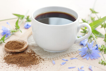 Chicory healthy drink in a glass cup with flowers, closeup, natural medicine and naturopathy concept
