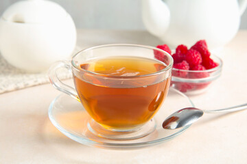 Delicious tea and raspberries on white table, closeup