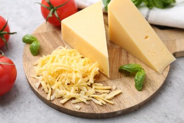 Tomatoes, basil, grated and pieces of cheese on light table, closeup