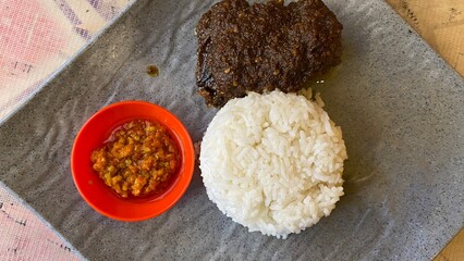 one portion of Rice with Black Spiced Duck and Sambal.