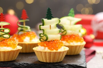 Tasty tartlets on grey table against blurred lights, closeup. Christmas appetizer