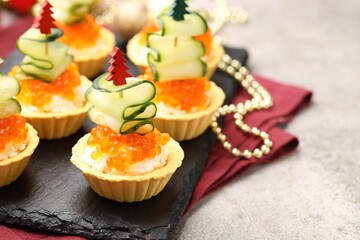 Tasty tartlets on grey textured table, closeup. Christmas appetizer