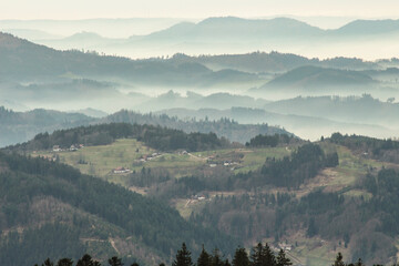 a mysterious landscape of mountains shrouded in fog and towering over the Mummelsee in Germany