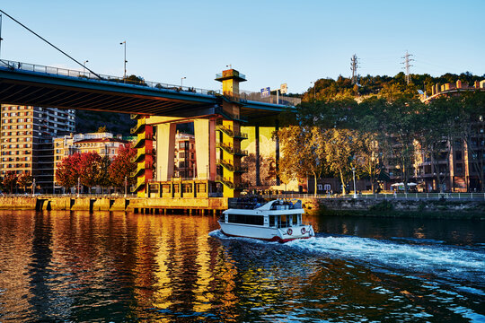Ferry boad going under the Principes de Espana bridge aka The La Salve Bridge in Bilbao, Basque, Spain, Europe 