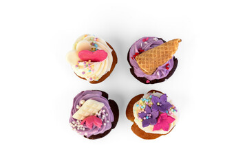 Delicious cupcakes with cream and sprinkles isolated on white background.
