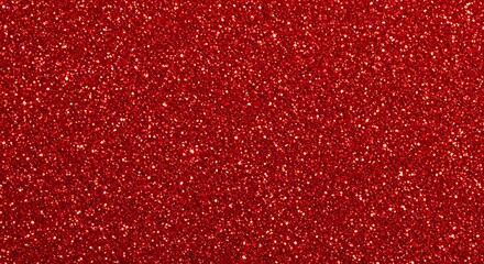 A textured background of shimmering red glitter with sparkling particles for festive design