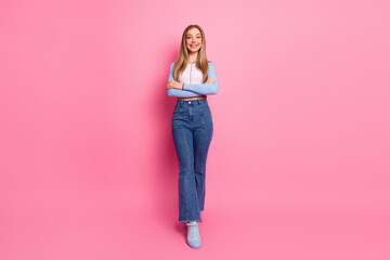 Charming blonde young woman in casual stylish denim attire standing confidently against a vibrant...