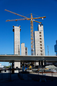 Yellow cranes on construction site of timber building Kaj 16 with hybrid concrete frames, sunny day, Lilla Bommen area on May 12, 2025 in Gothenburg, Sweden.
