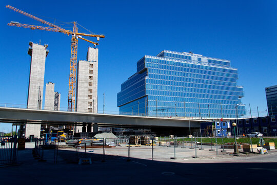 Yellow cranes on construction site of timber building Kaj 16 with hybrid concrete frames, sunny day, Lilla Bommen area on May 12, 2025 in Gothenburg, Sweden.
