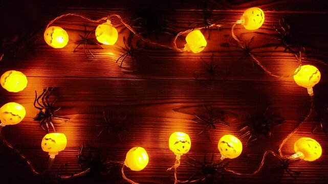 Ominous dark lanterns intermittently blinks, casting shadows over black spiders, making it an intriguing Halloween background for horror projects, copy space