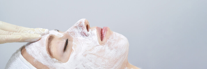 Caucasian female receiving skincare facial treatment with mask in spa.