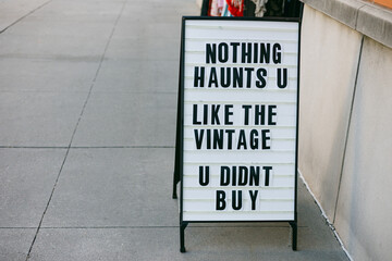Sign outside a store promoting vintage items with a humorous message