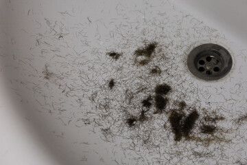 Man trimming beard and beard clippings in sink
