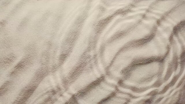 water drops impacting sand, gentle ripples radiating outward, ideal for promoting skincare and natural beauty products effortlessly, copy space