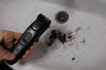 Man trimming beard and beard clippings in sink