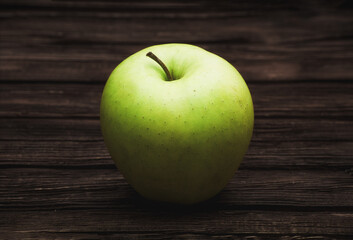 Green apple on dark brown wooden background. Summer fruits. Natural vitamins. Healthy food.