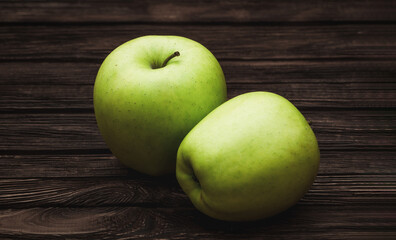 Green apples on dark brown wooden background. Summer fruits. Natural vitamins. Healthy food.