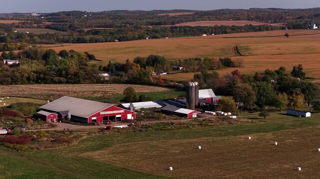 Typical farm house with barn and grain silos in peaceful countryside landscape in up state New York farmland