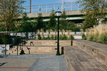 Modern urban park space with seating areas and greenery in a city setting