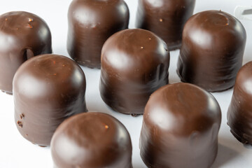 Chocolate covered marshmallow candy on white background