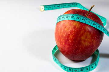 Red apple and measuring tape with white background