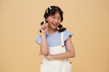 thinking Asian girl with playful have fun isolated on pastel background child studio portrait. childlike emotion and creative expression