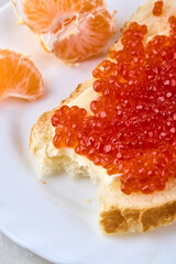 Sandwich with red caviar and tangerines. Traditional Russian treat on the New Year's table.