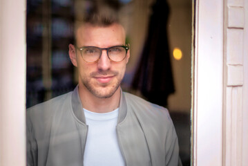 Portrait of a young man standing indoor and smiling