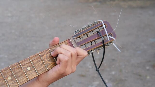 male hands playing guitar close up