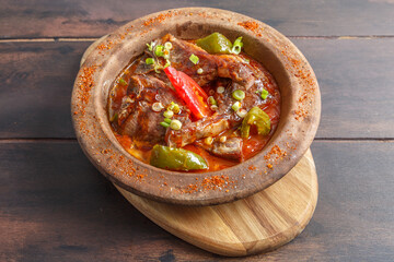 G&uuml;ve&ccedil; &agrave; la c&ocirc;te d&rsquo;agneau, plat turc traditionnel dans un plat en terre cuite sur table en bois. R&eacute;gion de Cappadoce. Gastronomie turque.. 