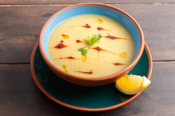 Soupe de lentilles turque Mercimek Çorbası, servie dans une vaisselle colorée avec un citron sur table en bois. Cuisine turque