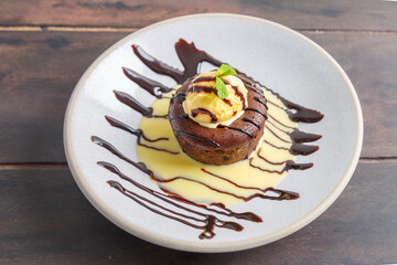 Fondant au chocolat avec une boule de glace présenté sur une table en bois