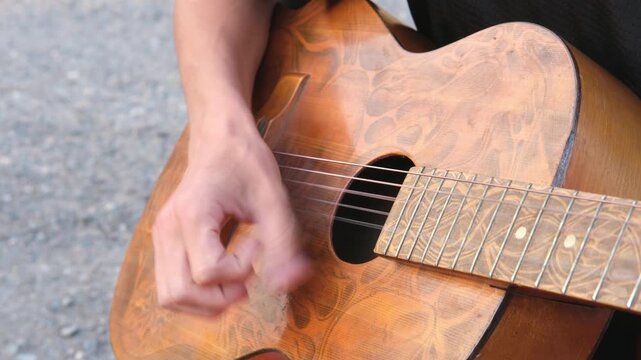 male hands playing guitar close up