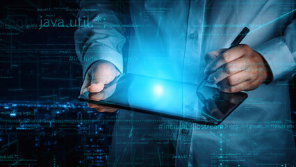 A software developer interacts with a digital tablet in a futuristic workspace, highlighting programming and coding activities enhanced by modern data visualization. Xenic